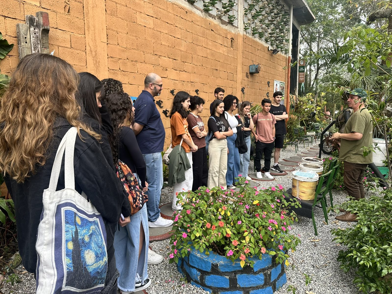 Turma ouvindo explicação no jardim