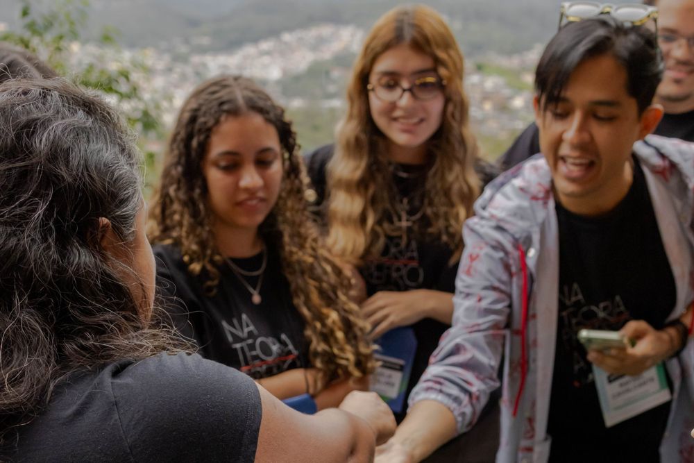 Visitantes sorrindo durante a visita guiada, com a cidade ao fundo